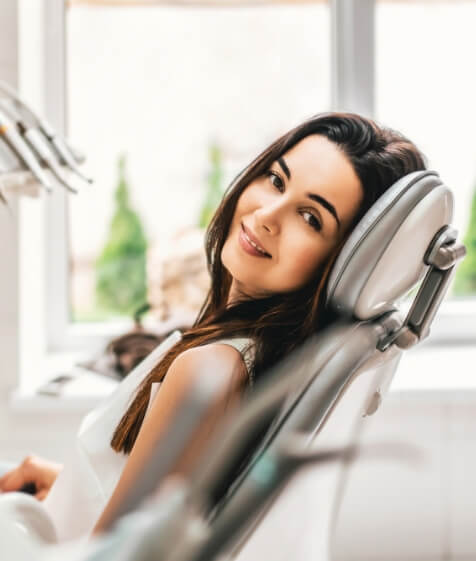 Smiling woman in dental chair for preventive dentistry visit