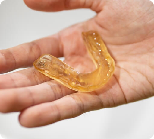 Hand holding a nightguard for bruxism