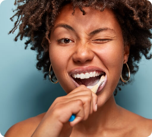 Woman brushing teeth to prevent dental emergencies