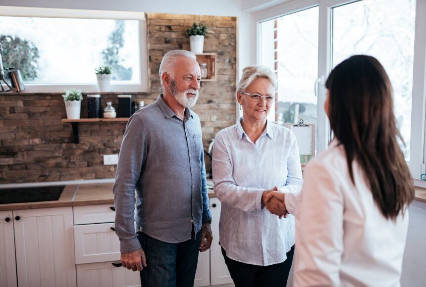 Older couple shaking hands with dental team member