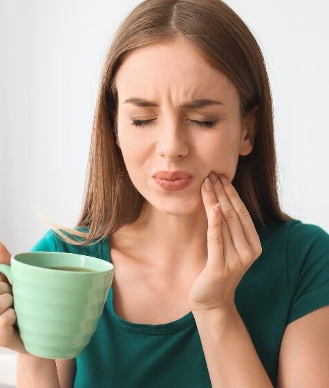 Woman holding jaw in pain before T M J treatment