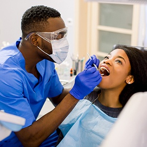 Closeup of dental assistant cleaning patient's teeth
